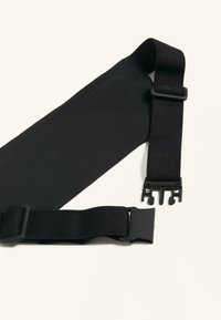 Fekete elasztikus pánt állítható kapcsokkal, sima textúrával és lapos kialakítással, biztonságos rögzítéshez tervezve.