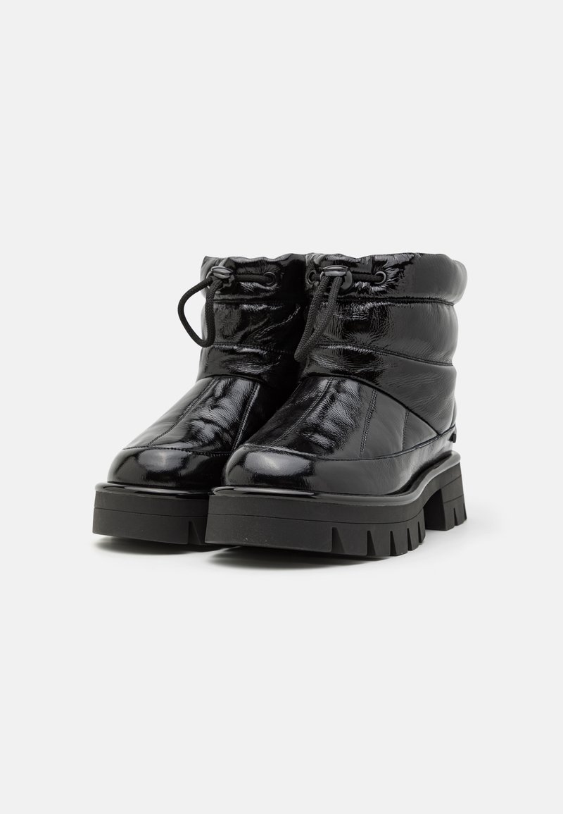 Stivali neri alla caviglia con finitura lucida, dotati di un design trapuntato, colletto imbottito e suola in gomma spessa e decorata. Lacci regolabili nella parte superiore.