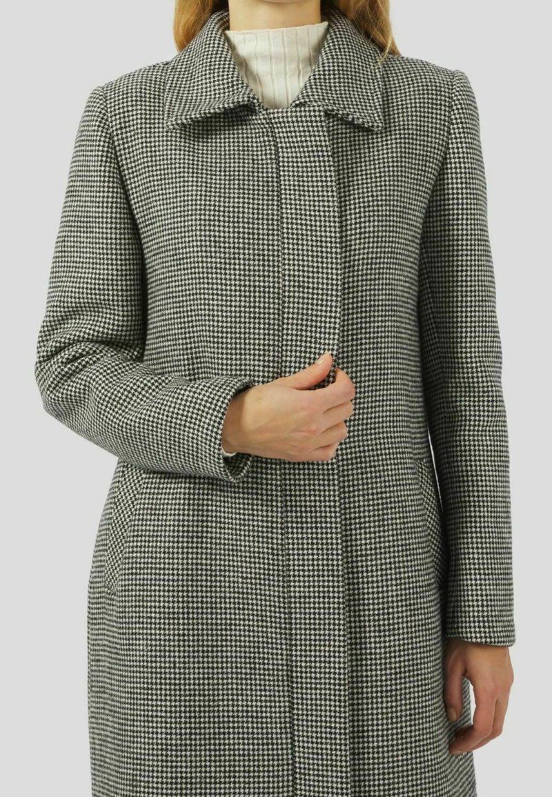 Abrigo de jacquard en grises y blancos con cuello de solapa, mangas largas y corte recto, con cierre de botones y bolsillos laterales.