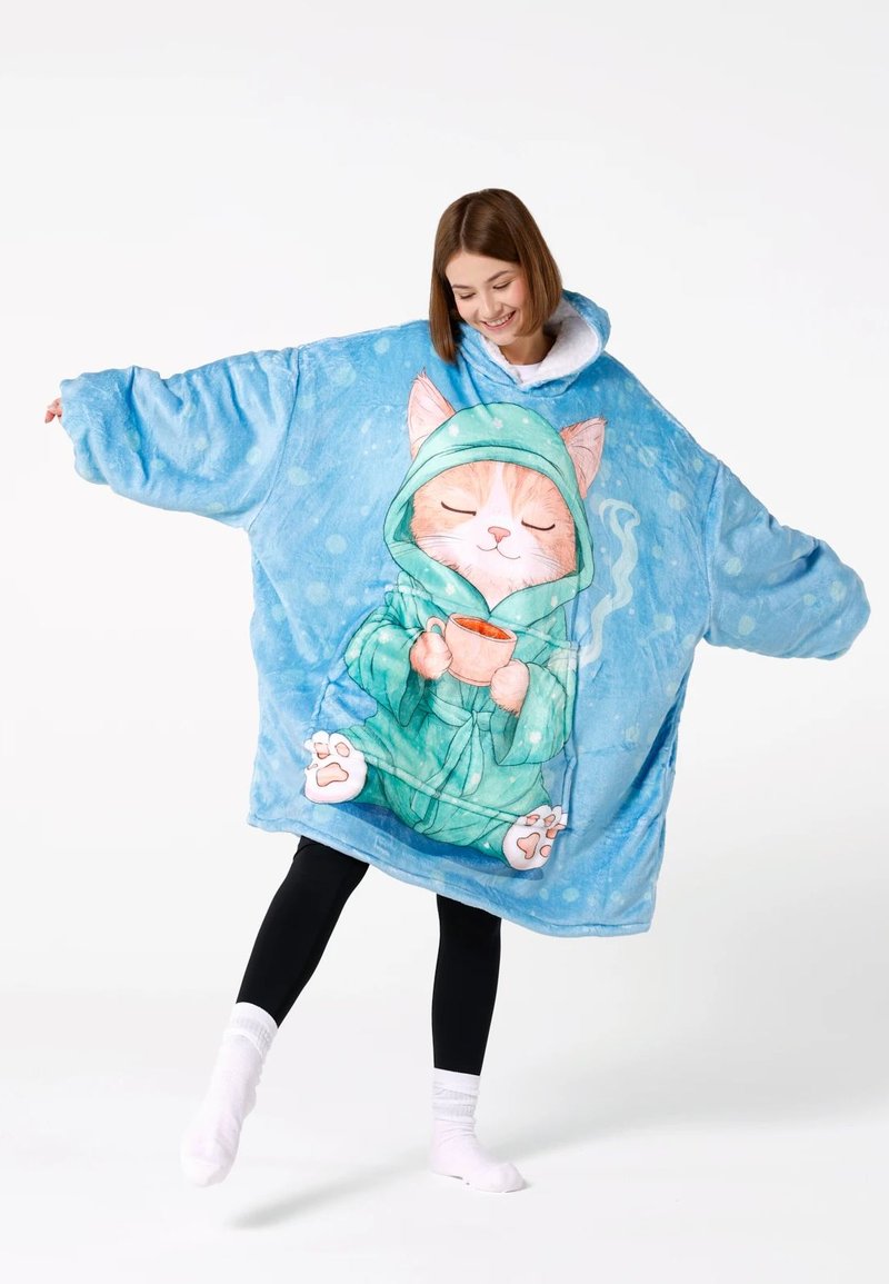 Liels zils kapucejums-pledu izgatavots no mīksta, pūkaina auduma. Iezīmē kaķa ilustrāciju, zaļu kapuci un ērti siltu dizainu ar punktiņiem.