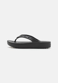 Sandales tongs noires en caoutchouc avec un fond texturé, des brides fines et une semelle rembourrée dotée de petits points surélevés pour une meilleure adhérence.
