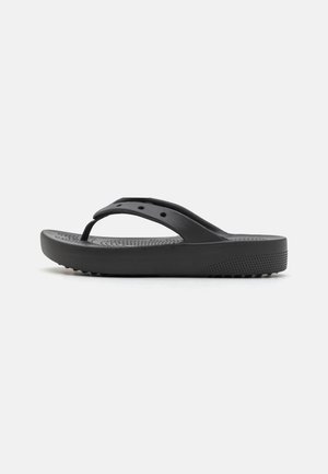 Sandales tongs noires en caoutchouc avec un fond texturé, des brides fines et une semelle rembourrée dotée de petits points surélevés pour une meilleure adhérence.