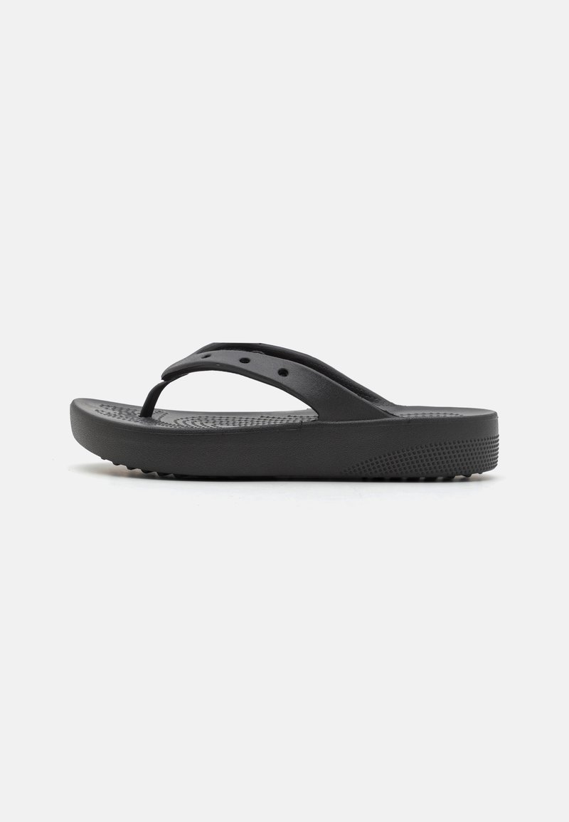 Sandales tongs noires en caoutchouc avec un fond texturé, des brides fines et une semelle rembourrée dotée de petits points surélevés pour une meilleure adhérence.