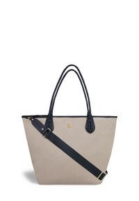 Sac fourre-tout beige avec des accents en cuir noir, anses doubles, bandoulière réglable et logo doré. Texture lisse, intérieur spacieux, forme structurée.
