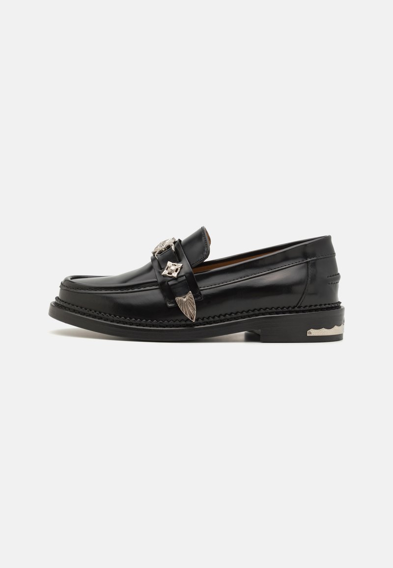 Mustad nahast loafers, ümarate varvastega, kaunistatud lehekujundusega metalldetailidega ja tekstuurse musta kummitaldaga.
