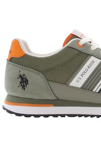 Green suede and mesh sneaker with a white midsole, orange accents, and a polo player logo on the heel. Features round laces and a padded collar.