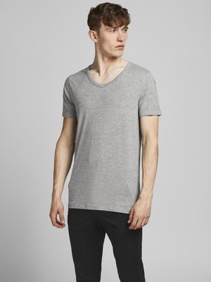 T-shirt gris à manches courtes en col V, fabriqué dans un tissu doux, présenté avec une coupe décontractée et une texture lisse, associé à un pantalon noir.