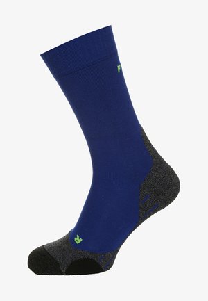 Calzino blu con parte superiore a coste, soletta grigia imbottita, punta rinforzata e dettaglio logo verde. Presenta una texture liscia e un design sportivo.