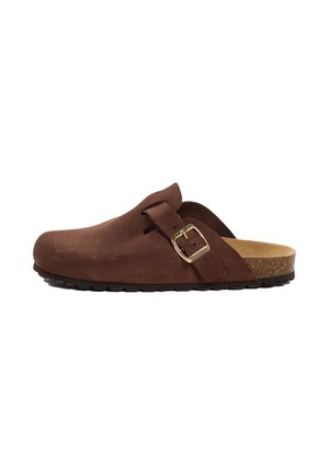 Ruskea mokkanahkainen slip-on-puukenkä, jossa suljettu kärki, avoin kanta, korkkipohjallinen, musta pohja ja kultainen solki sivussa.