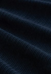 Ciemnogranatowa prążkowana tkanina o miękkiej fakturze, złożona z naprzemiennie wystających i zagłębionych linii, tworzących wyraźny wzór i głębię.