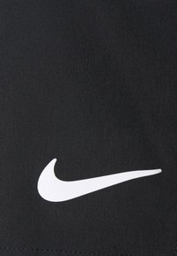 Schwarze Sportshorts aus weichem Material, mit einem auffälligen weißen Nike-Swoosh-Logo auf der Vorderseite.