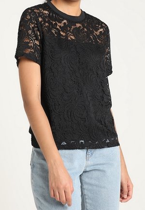 Schwarzes Spitzen-T-Shirt mit einem floralen Muster, rundem Halsausschnitt, kurzen Ärmeln und einem schlichten Saum, kombiniert mit hellblauen Jeans.