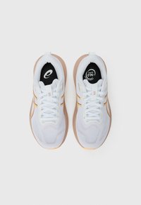 White athletic shoes with a mesh upper, yellow accent stripes, and a beige sole. Features round black insole logo and traditional lacing.