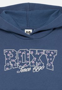 Blue hoodie with "ROXY" in floral-patterned letters and "Since 1990" written underneath in white script font.
