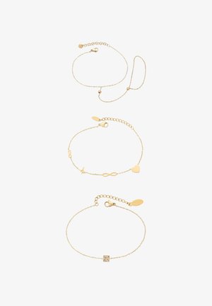 Kolme kultaranneketta, joissa eri muotoiluja: yhdessä riipuksia (sydän, ääretön-symboli, salamanisku), toisessa suorakaiteen muotoinen jalokivi.