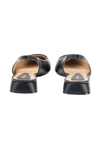 Zapatos negros de cuero tipo slip-on con parte trasera abierta, tacón bajo y textura suave. El interior presenta una plantilla color crema con detalle del logo.