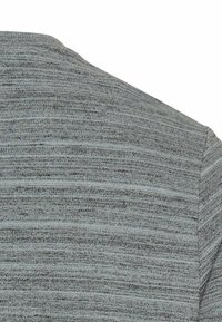 Grå strikket sweater med et tekstureret, horisontalt stribemønster. Har en rund halsudskæring og korte ærmer, hvilket giver en afslappet pasform.