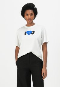 Witte katoenen t-shirt met een blauw hartafbeelding en de tekst "I ♥ U" in zwart en blauw. Het shirt heeft een relaxte pasvorm en korte mouwen.