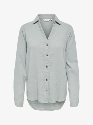 Világosszürke, hosszú ujjú, gombos ing laza szabással, hegyes gallérral és enyhén texturált anyaggal.