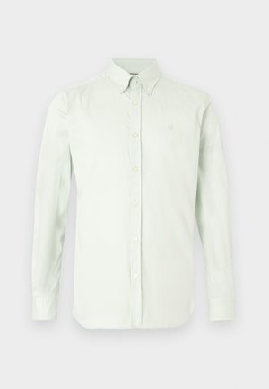 Világoszöld, hosszú ujjú, patentos ing, klasszikus gallérral, elöl végig gombolható, és a mellkason finoman hímzett logóval.