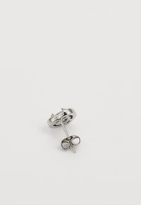 Silberne Metall-Stiftohrringe mit rundem Design, ausgestattet mit einem detaillierten Ausstanzungsmuster. Enthält einen geraden Stift und einen Schmetterlingsverschluss.