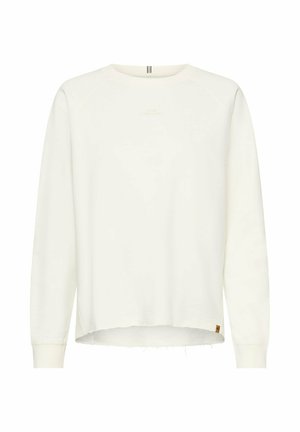 Long-sleeve white crewneck sweatshirt with raw hem and subtle text "LIVING IN THE MOMENT" on the chest.