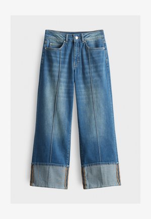 Jeans a gamba larga in denim blu, con un lavaggio chiaro, orlo a contrasto con motivo testurizzato e design classico a cinque tasche.