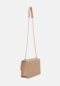 Beżowa prostokątna torebka z klapką, złotym łańcuszkiem oraz miękkim beżowym paskiem na ramię na białym tle.