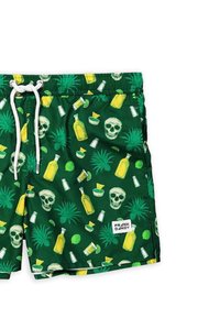 Pantaloni da bagno verdi con stampa tropicale che presenta teschi, bottiglie, lime e ananas. Include un cordoncino bianco e un'etichetta con il marchio.