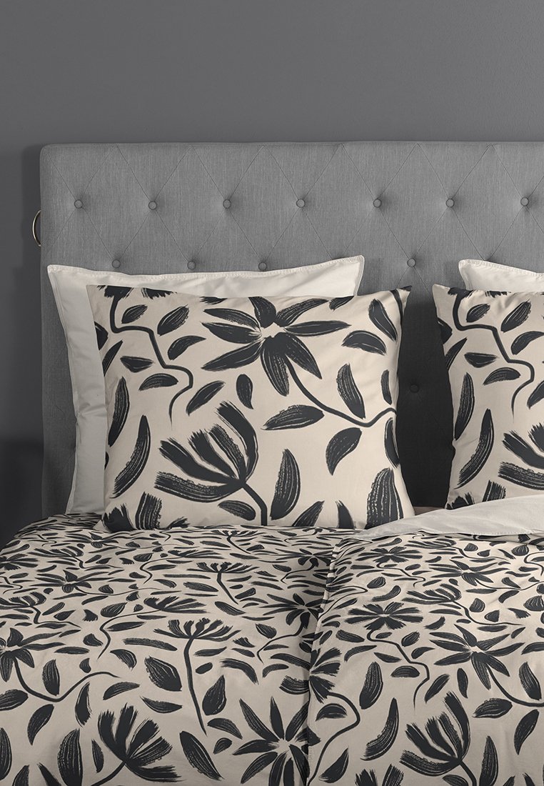 Set di biancheria da letto floreale con uno sfondo crema e motivi di foglie e fiori neri. Tessuto morbido, comprende due cuscini coordinati e una copertura per duvet.