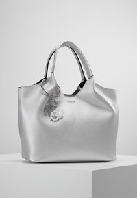 Zilveren lederen tote bag met een textuur oppervlak, zwarte binnenkant en dubbele handvatten. Beschikt over een sleutelhanger met logo-accenten.