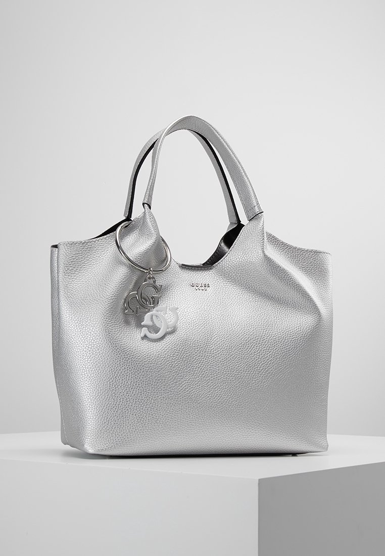 Zilveren lederen tote bag met een textuur oppervlak, zwarte binnenkant en dubbele handvatten. Beschikt over een sleutelhanger met logo-accenten.