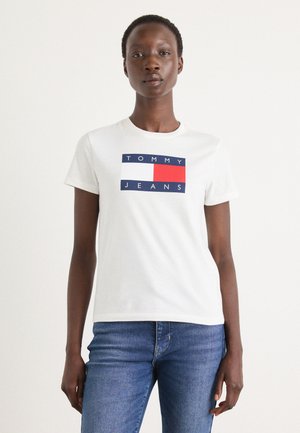 T-shirt en coton blanc à manches courtes, avec un graphique en bleu, rouge et blanc affichant "TOMMY JEANS" centré sur le devant.