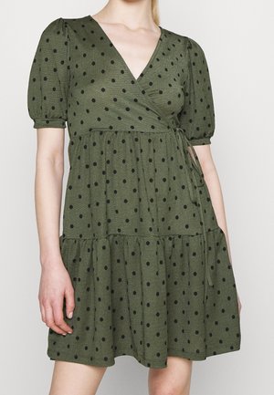 Zelené zavinovací šaty s puntíky, krátkými nafouklými rukávy, výstřihem do V, stříhanou sukní a páskem v pase. Měkká, texturovaná látka.