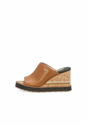 Bruine leren wedge sandalen met kurken basis, open teen en een getextureerde zwarte rubberen zool met subtiele designelementen en branding.