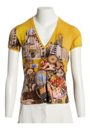 Top amarillo de manga corta con escote en V con un estampado collage de edificios, personas y platos decorativos, llevado por un maniquí con pantalones blancos.