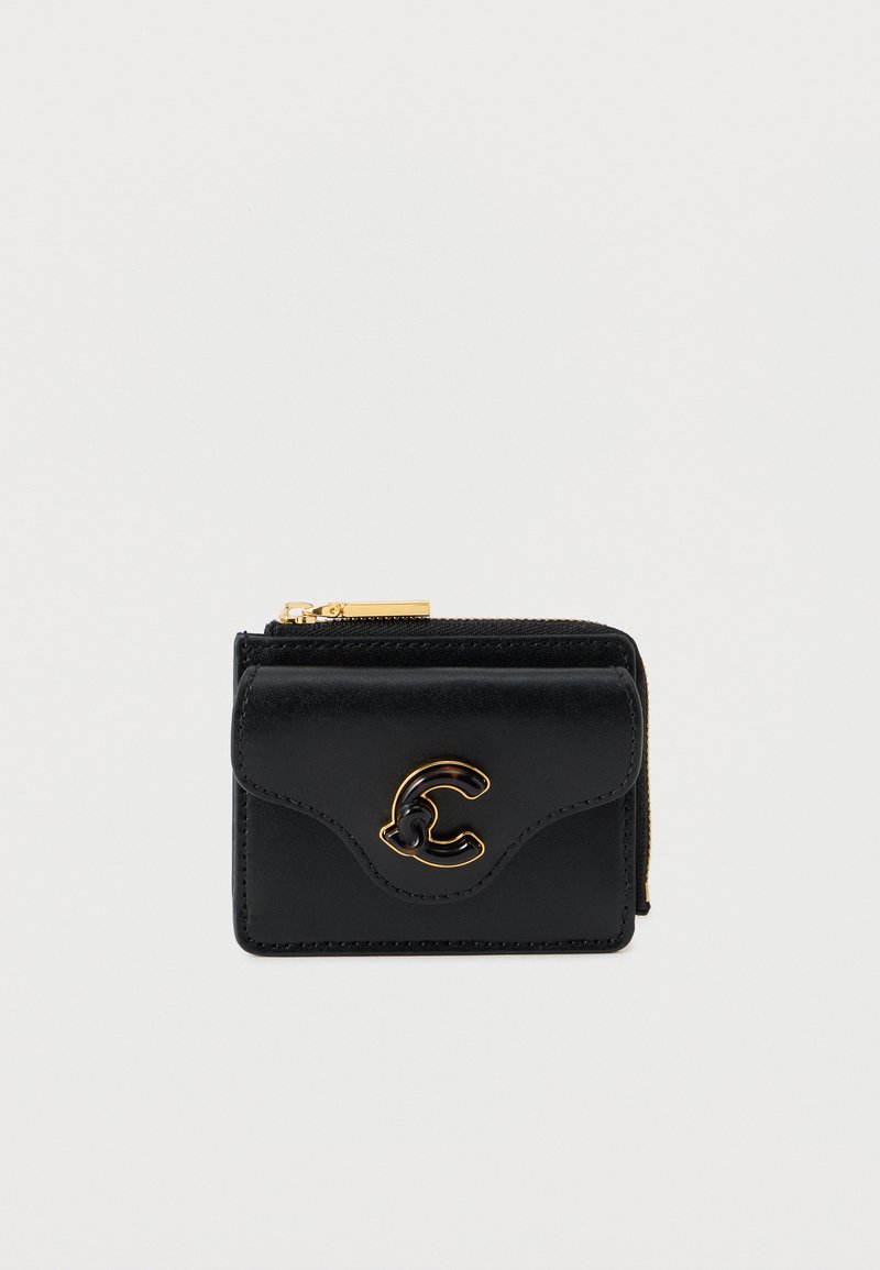 Musta nahkalompakko, jossa on kullanvärinen vetoketju ja kohotettu "C"-kirjain etupuolella. Lompakossa on teksturoitu pinta ja kaareva läppäsuunnittelu.