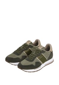 Zapatillas verdes que combinan materiales de ante y malla, con una suela blanca, cordones y branding en el lateral en contrastantes acentos marrones.