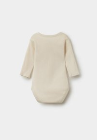 Dětský overal s dlouhým rukávem v světlém béžovém odstínu z bavlny, s kulatým výstřihem a patentkami na dně pro snadné oblékání.