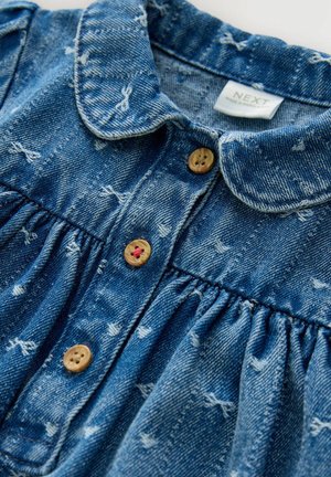 Jeanskleid mit Kragen in Hellblau, verziert mit weißen Mustern, Holzknöpfen und gerafftem Stoff an der Taille.