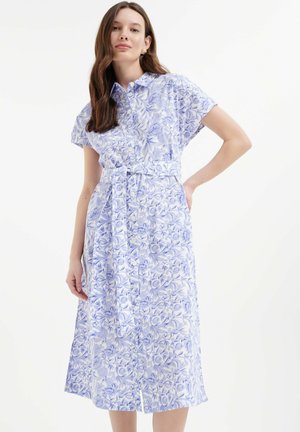 Floral button-up dress in light blue and white, featuring short sleeves, a fitted waist, and a lined hem. Smooth cotton fabric with a silky texture.