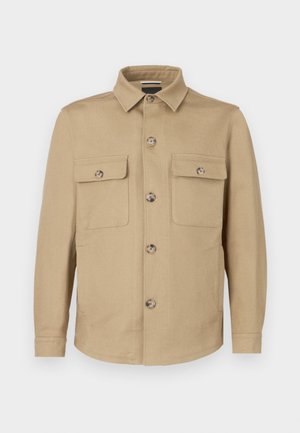 Giacca beige realizzata in tessuto morbido con chiusura frontale a bottoni, due tasche sul petto e collo con rever. Texture liscia e vestibilità sartoriale.