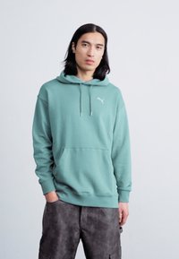 Felpa leggera verde chiaro con tasca a marsupio frontale e cappuccio con cordino. Presenta un piccolo logo bianco sul petto e polsi a coste.