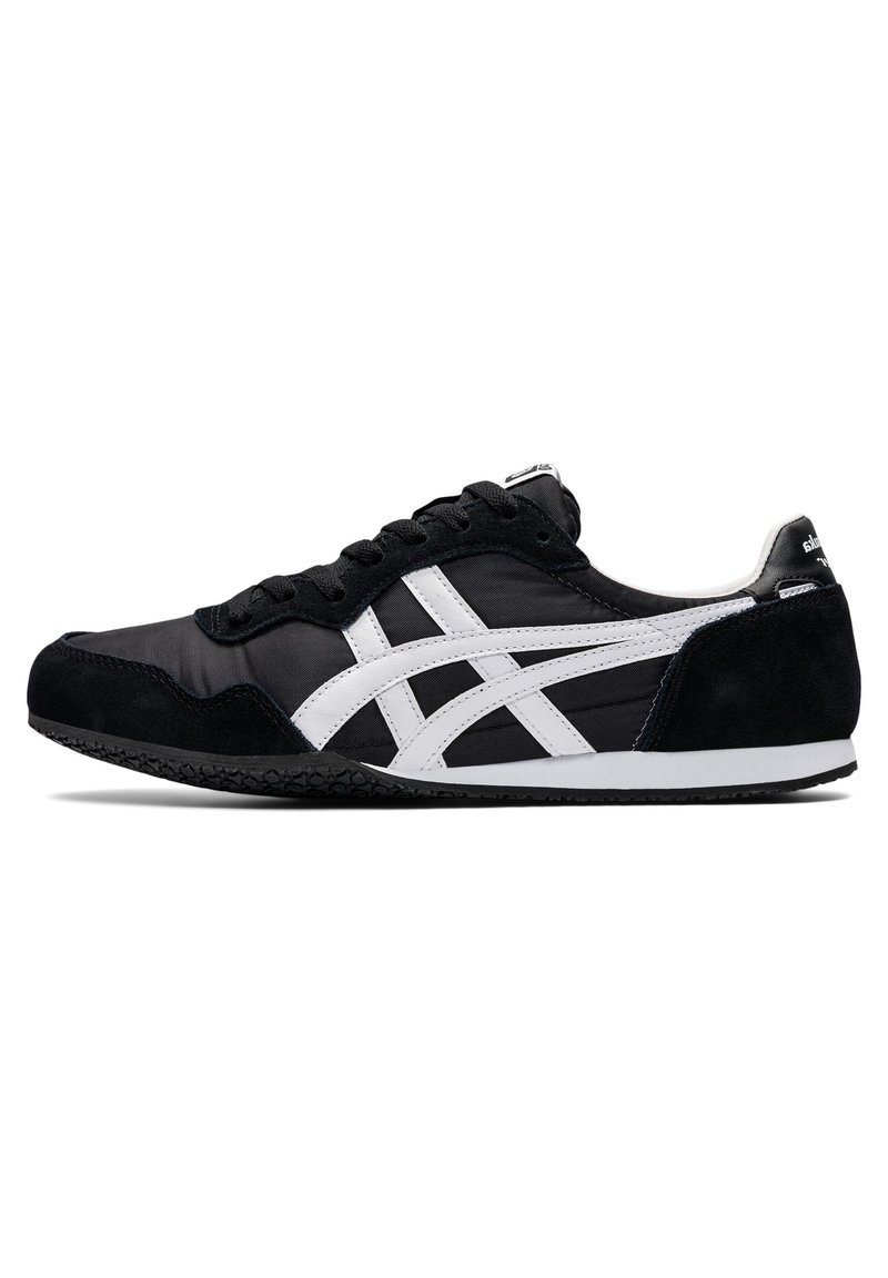 Black sneaker with white side stripes, made of a mix of fabric and suede. Flat rubber sole with a textured pattern; simple lace-up design.