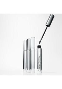Tubi di mascara Clinique con finitura cromo, altezze variabili, con un applicatore nero sollevato sopra un tubo. Il testo sul lato recita "Solo in cerca".