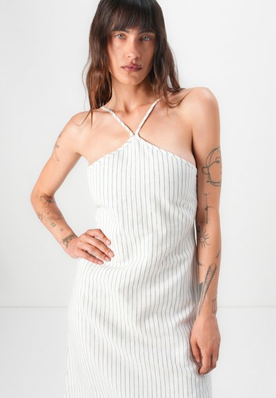 Robe en tissu blanc avec des rayures verticales bleu marine, design à col halter, silhouette ajustée et fines bretelles. Texture lisse et style simple.