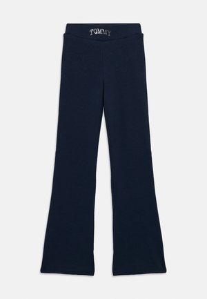 Námornícke modré zvonové nohavice s elastickým pásom, na ktorých sú v bielych písmenách napísané slová "TOMMY".