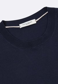 Maglione lavorato a maglia blu navy con collo rotondo texturizzato e un'etichetta con la scritta "Paolo Pecora Milano" su uno sfondo crema.