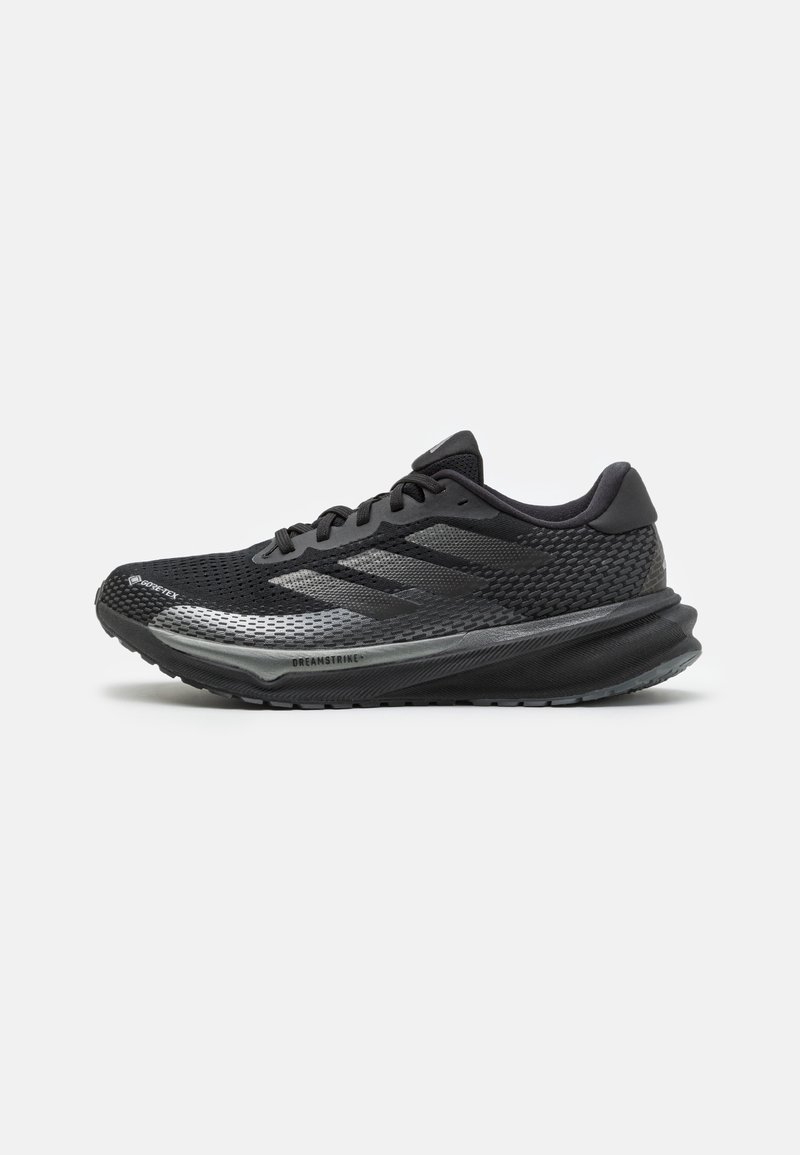 Chaussure de course noire avec dessus en mesh, fermeture à lacets, semelle épaisse et rembourrée, discrètes rayures foncées et texte "DREAMSTRIKE+" près de la semelle.