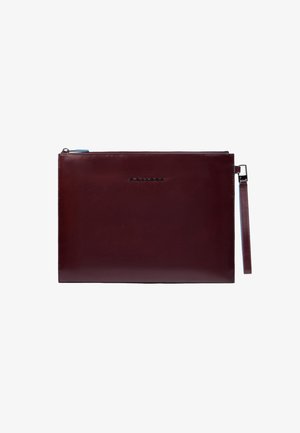 Bordeauxrood leren clutch met een gladde textuur, voorzien van een ritssluiting en een afneembare polsband. Voorzien van een logo in reliëf.